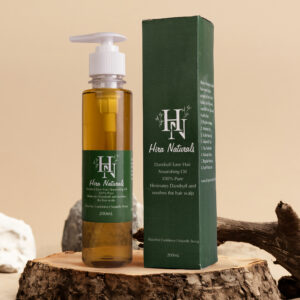 Bottle of Dandruff Ease Hair Nourishing Oil by Hira Naturals, shown with neem leaves, fenugreek, and rose petals, highlighting its herbal anti-dandruff properties.