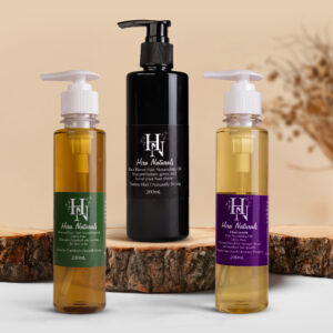 Set of three Hira Naturals Hair Oils—Black Bloom, Vitagrowth, and Dandruff Ease—displayed with natural ingredients, representing strength, growth, and anti-dandruff benefits.